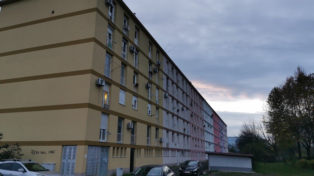 Višebojna fasada stambene zgrade u zagrebačkom Voltinu, parkirana vozila ispred ulaza